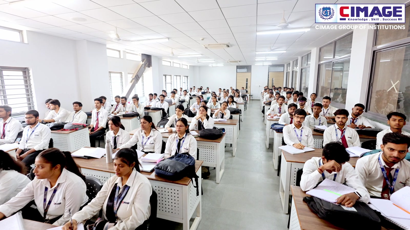 Wide-angle view of a large classroom filled with seated students.