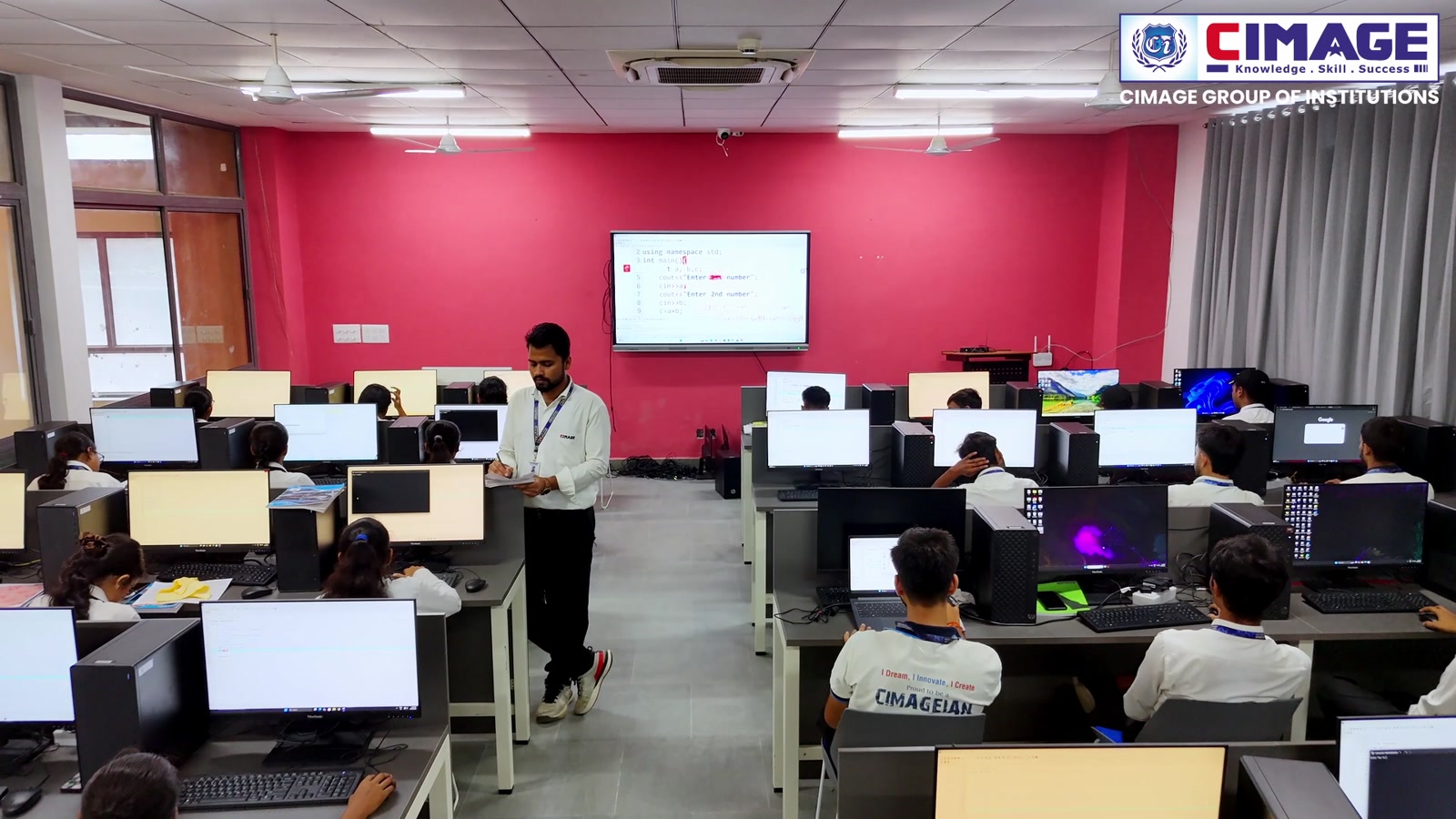 Students working at computers in a modern laboratory environment.